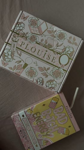 Reviewer's P.Louise Bad Bitch Energy Lip Duo in its fun juice-box packaging, next to its floral shipping box.
