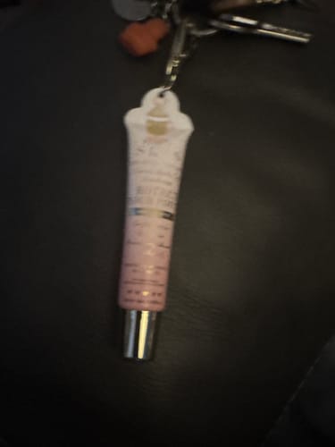 Reviewer's P.Louise Lip Duo attached to a set of keys on a dark surface.