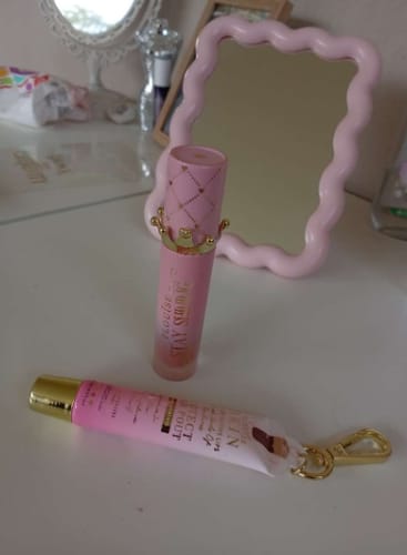 Customer's Bad Bitch Energy Lip Duo, the lip oil and conditioner, showing the pink packaging on a vanity.